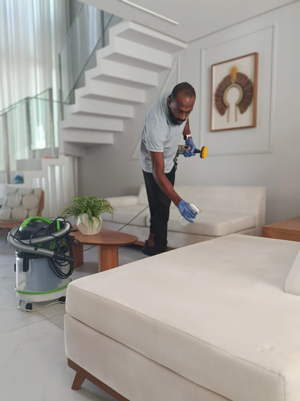 Profissional realizando limpeza de sofá claro; atendimento da Ms Clean na Barra, Salvador